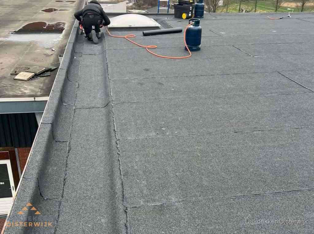 Dakdekker repareert bitumen dakbedekking op groot plat dak in Oisterwijk