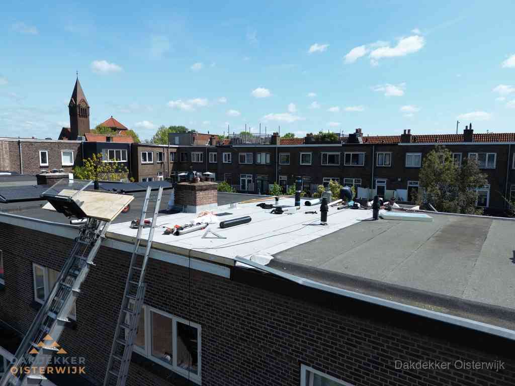 Dakdekkers aan het werk op plat dak in Oisterwijk