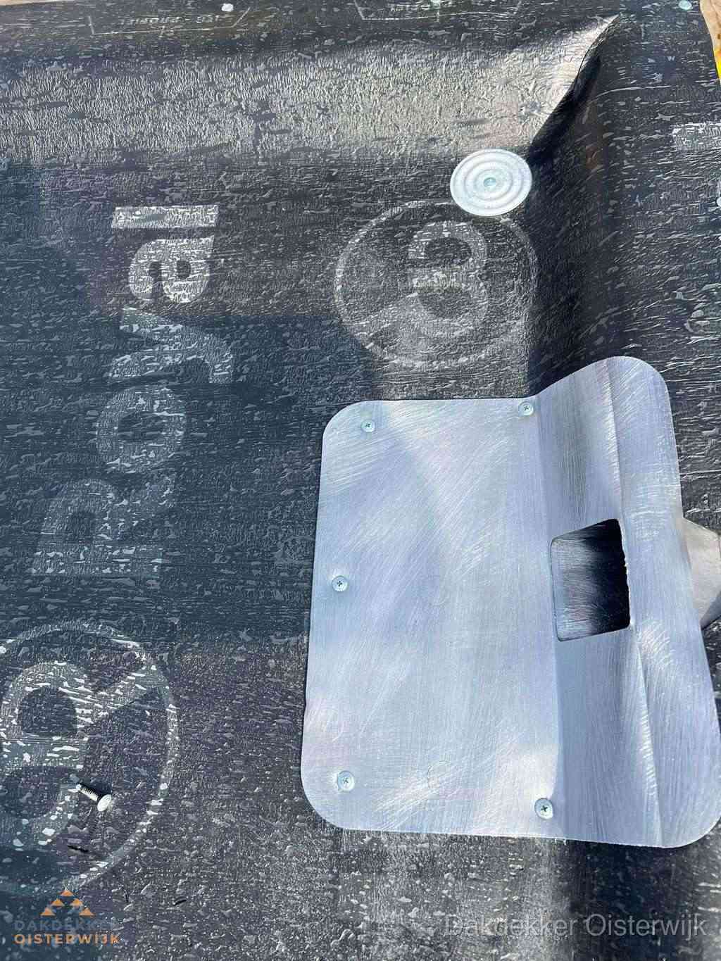 Dakdoorvoer met metalen afvoerplaat op bitumen dak in Oisterwijk