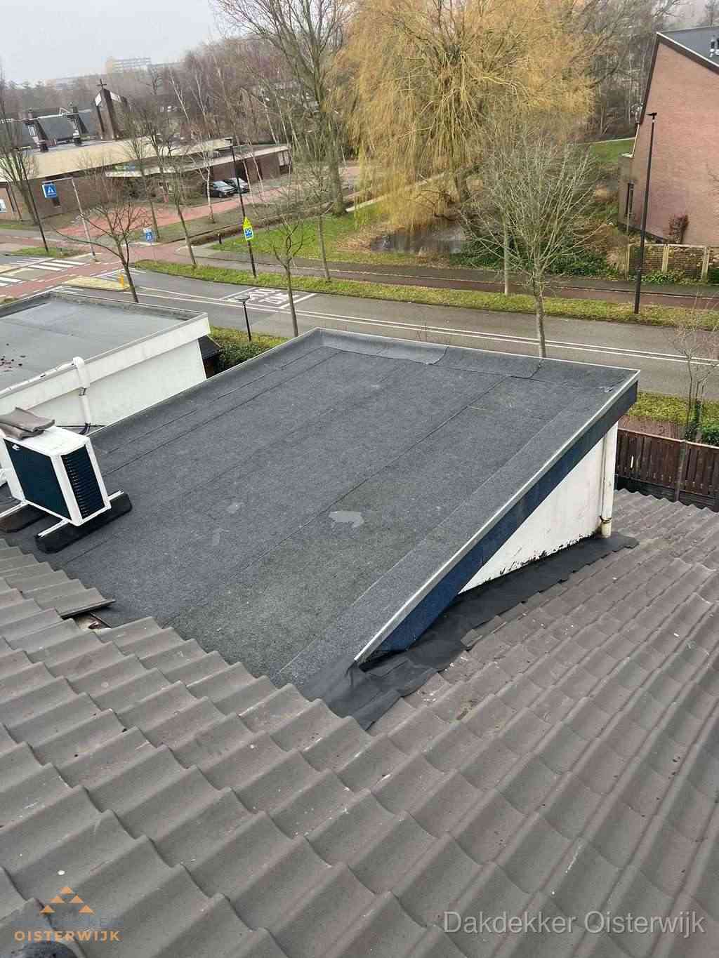 Plat dak met bitumen dakbedekking naast schuin pannendak in Oisterwijk
