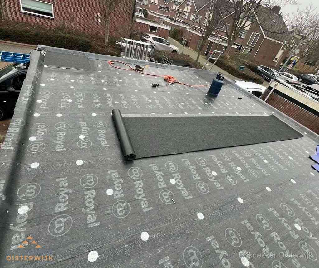 Dakdekker aan het werk met gasbrander op plat bitumen dak in Oisterwijk